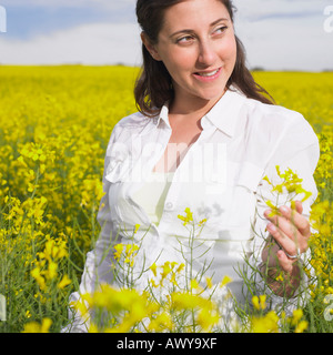 Femme Debout dans champ de canola, Alberta, Canada Banque D'Images