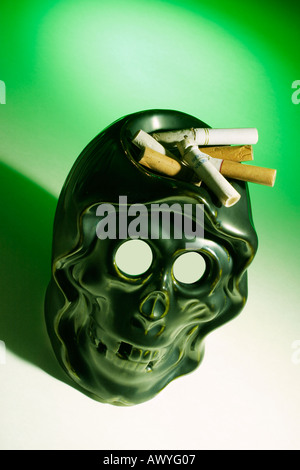 Les mégots sur cendrier crâne Banque D'Images