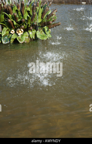 Les eaux s'écoulent d'une fontaine dans un étang à St Stephen's Green, Dublin Irlande avec une usine de traitement de l'eau dans le coin Banque D'Images
