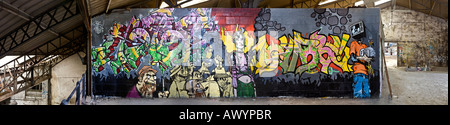 Graffiti dans une friche industrielle, située à Vichy (France). Vue panoramique d'un graffiti dans une usine désaffectée de Vichy. Banque D'Images