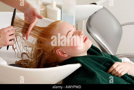 Jeune femme ayant les cheveux lavés au salon Banque D'Images