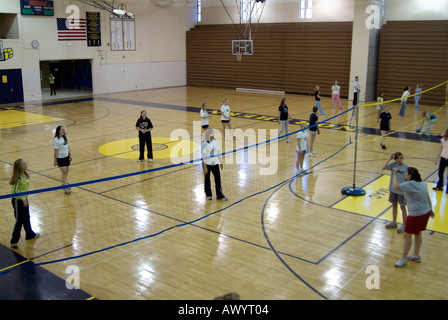 High school student femmes participer à une classe d'éducation physique dans un gymnase volley-ball Banque D'Images