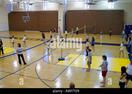 High school student femmes participer à une classe d'éducation physique dans un gymnase volley-ball Banque D'Images