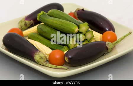 Les légumes non cuits dans une assiette de bébé Banque D'Images