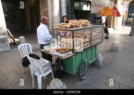 Un homme sellling pain traditionnel à un marché dans la vieille ville de Jérusalem Banque D'Images