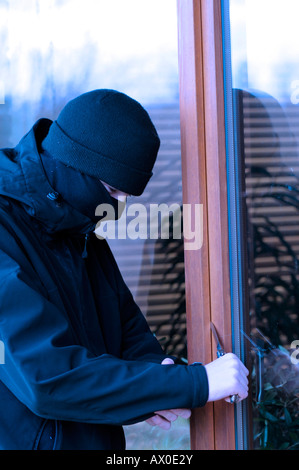 Les jeunes qui violent-et-saisie à l'aide d'un couteau pour ouvrir les portes du patio Banque D'Images