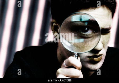 Portrait of young man holding magnifying glass Banque D'Images