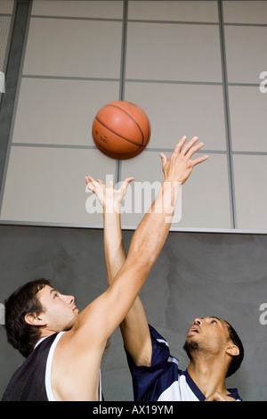 Deux joueurs de basket-ball pour atteindre un terrain de basket-ball Banque D'Images