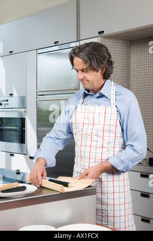 Un homme mûr la préparation de sushi dans la cuisine Banque D'Images