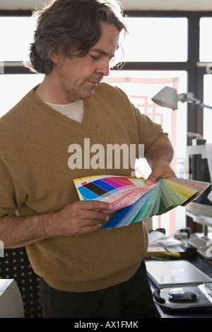 Un homme tenant des couleurs du nuancier dans un bureau Banque D'Images