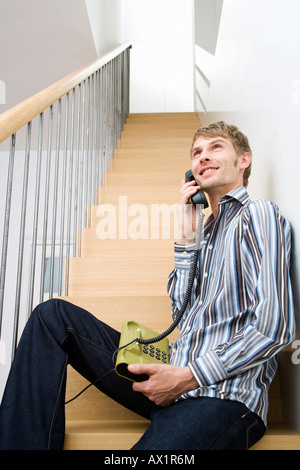 A assise sur un escalier sur le téléphone Banque D'Images