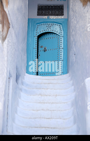 Escaliers blancs mènent à une porte bleue medina Chefchaouen Maroc Banque D'Images