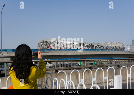 Une jolie femme organiser un tournage caméra Niaochao Bird's Nest(Beijing National Stadium) Banque D'Images