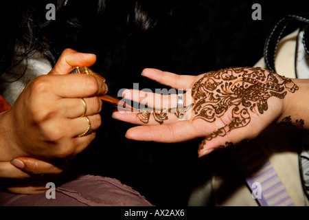 Jeune femme peinture tatouage au henné (mehndi) sur place au Salon de l'Asie, Londres, Olympia 2006 Banque D'Images