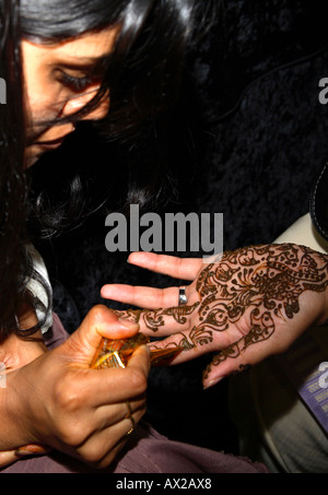 Jeune femme peinture tatouage au henné (mehndi) sur place au Salon de l'Asie, Londres, Olympia 2006 Banque D'Images