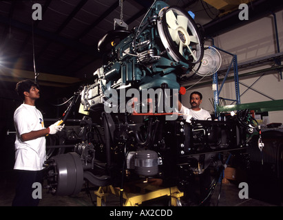 Les travailleurs expatriés, pose du moteur sur le châssis du camion à l'usine d'assemblage de Volvo à Jeddah en Arabie Saoudite Banque D'Images