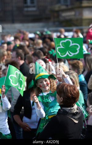 Jeune fille dans fancy dress costume irlandais Waving Flag dans la foule au concert et carnaval à custom house square St Patricks Banque D'Images