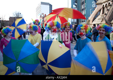 Clowns avec parasols en prenant part au défilé et carnaval sur St Patricks day belfast Irlande du Nord Banque D'Images