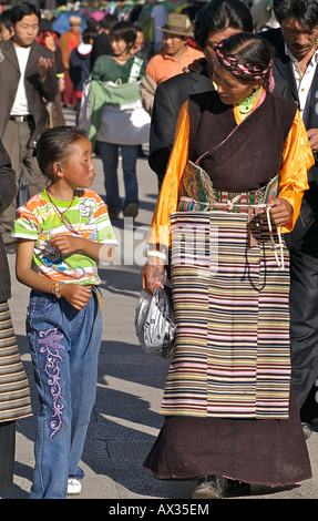Mère tibétaine dans un style traditionnel avec sa fille marche Robe habillé en robe moderne. Lhassa, Tibet Banque D'Images