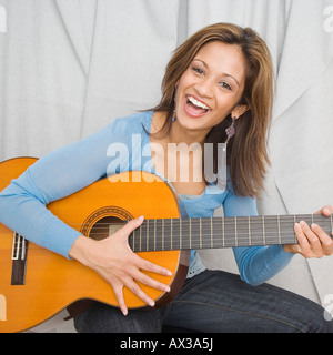 Indian woman playing acoustic guitar Banque D'Images