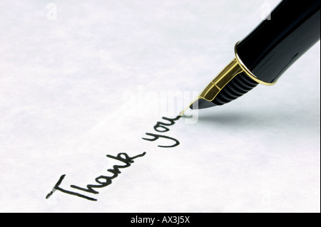 Merci écrit sur papier texturé en filigrane à l'aide d'un stylo-plume or nibbed correspondant se trouve sur le texte Banque D'Images