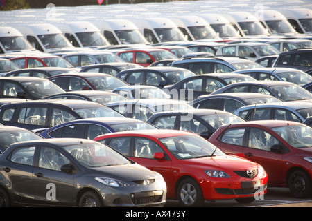 Rangées de nouvelles voitures et cars dans un lot de voiture en attente de distribution Banque D'Images