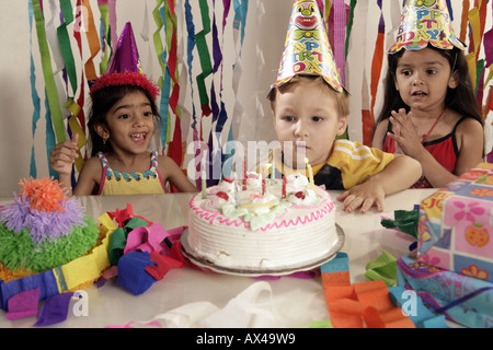 Les garçons blowing candles dans une fête Banque D'Images