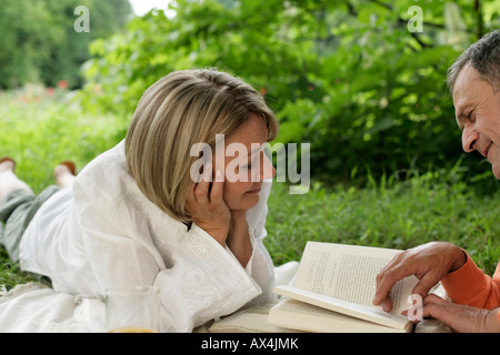 Homme mature femme montrant quelque chose dans un livre Banque D'Images