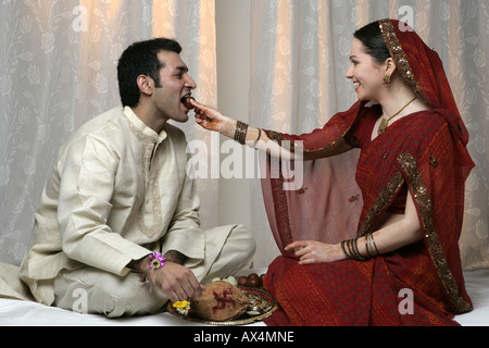 Frère et sœur célébrant Raksha bandhan et manger des douceurs Banque D'Images