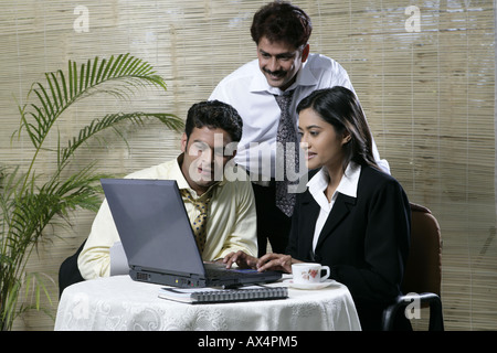 Trois business people working on laptop in office Banque D'Images