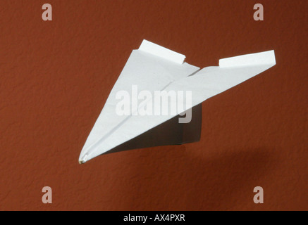 Avion de Papier blanc vole si air contre fond brun Banque D'Images