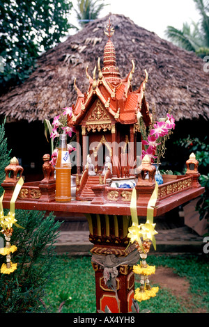 Un sanctuaire bouddhiste en Thaïlande avec une bouteille de Fanta à gauche comme une offrande. Banque D'Images