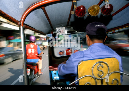 Un tuk tuk photographié à partir de la banquette arrière s'il conduit à travers les rues de Bangkok en Thaïlande. Banque D'Images