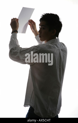 Man holding feuille de papier dans ses mains Banque D'Images