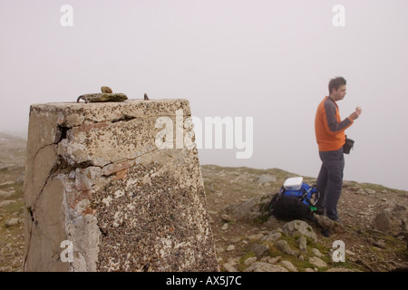 Abscisse Hillwalker snack-à côté du sommet trig point sur Garnedd Ugain Banque D'Images