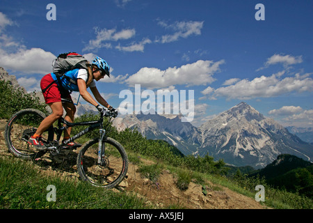 Vélo de montagne femelle, Mt. Antelao en arrière-plan, Dolomites, Italie du Nord, en Europe Banque D'Images