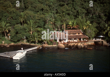 Ilha Grande, Brésil. Maison de vacances moderne de luxe construit à proximité de la mer avec véranda et des hamacs, bateau à moteur. Banque D'Images