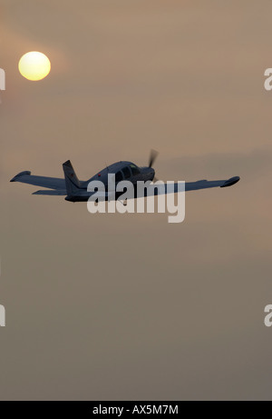 Piper les aéronefs volant dans le soleil du soir sur l'océan (composite), Egelsbach, Hesse, Germany, Europe Banque D'Images