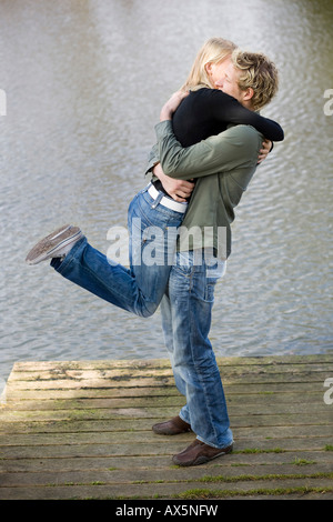 Homme Femme de levage sur un quai en bois Banque D'Images