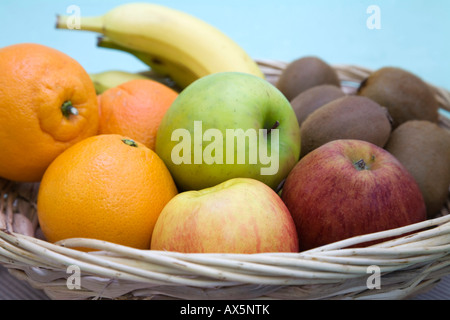 Détail d'un panier de fruits avec des oranges, pommes, bananes et kiwis Banque D'Images