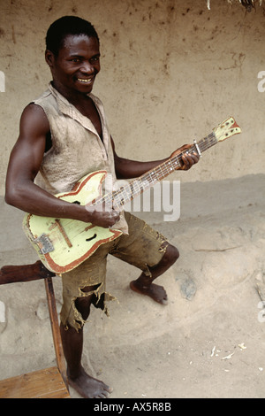 Kipili, Tanzanie. Jeune homme jouant sur une guitare en bois. Banque D'Images