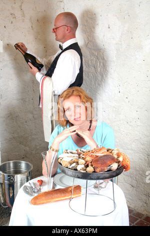 Jeune femme d'être attendu dans un restaurant de fruits de mer Banque D'Images