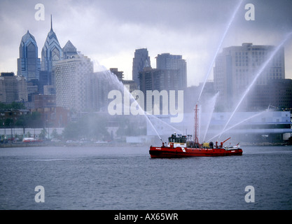 Un bateau-pompe pulvérise l'eau en face de la skyline de Philadelphie, Pennsylvanie Banque D'Images