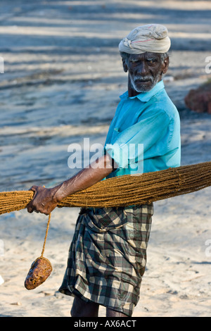 Hommes dans les filets de pêche sur la plage de Varkala en Inde Banque D'Images