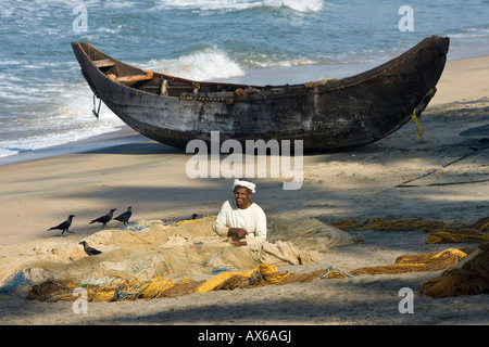 Fisherman Mending des filets sur la plage de Varkala en Inde Banque D'Images