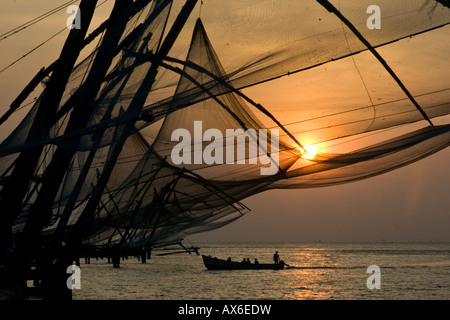 Bateau de pêche et filets de pêche chinois au coucher du soleil à Cochin Inde Banque D'Images