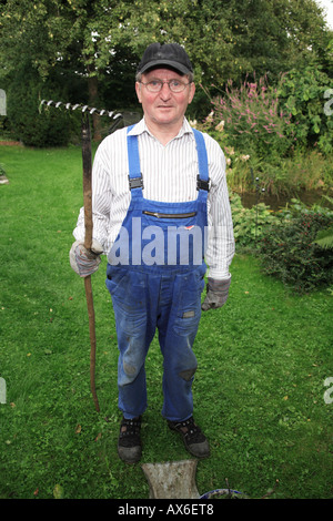 66 ans dans les vêtements de travail de faire travailler le jardin. L'Allemagne, de l'Europe Banque D'Images
