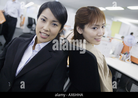 Deux femmes assises en face l'un à l'autre et regardant la caméra Banque D'Images