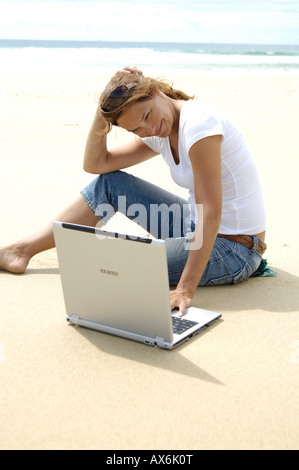 Close-up of woman using laptop on the beach Banque D'Images