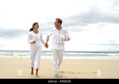 Couple running on beach Banque D'Images